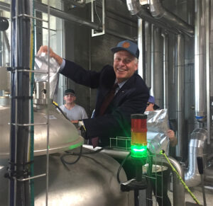 Virginia Gov. Terry McAuliffe dumps hops into the collaboration imperial stout brewed at Stone Brewing Co. in Richmond. Photo by Lee Graves