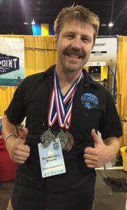 Ryan Aldridge, vice president of sales for Blue Mountain Brewery, sports the three medals won by the brewery's group. Photo by Lee Graves